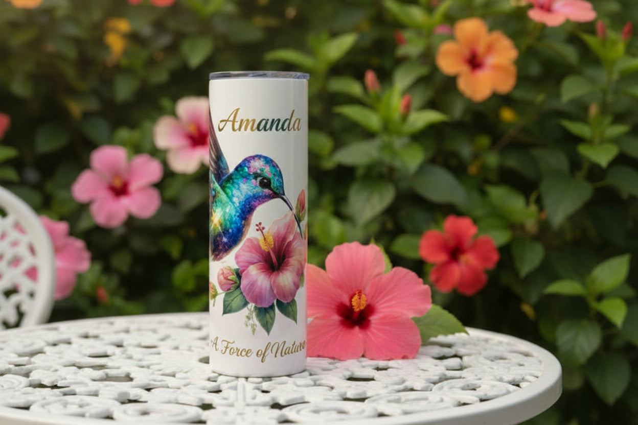 Tumbler with a colorful hummingbird and pink flower design on a white background