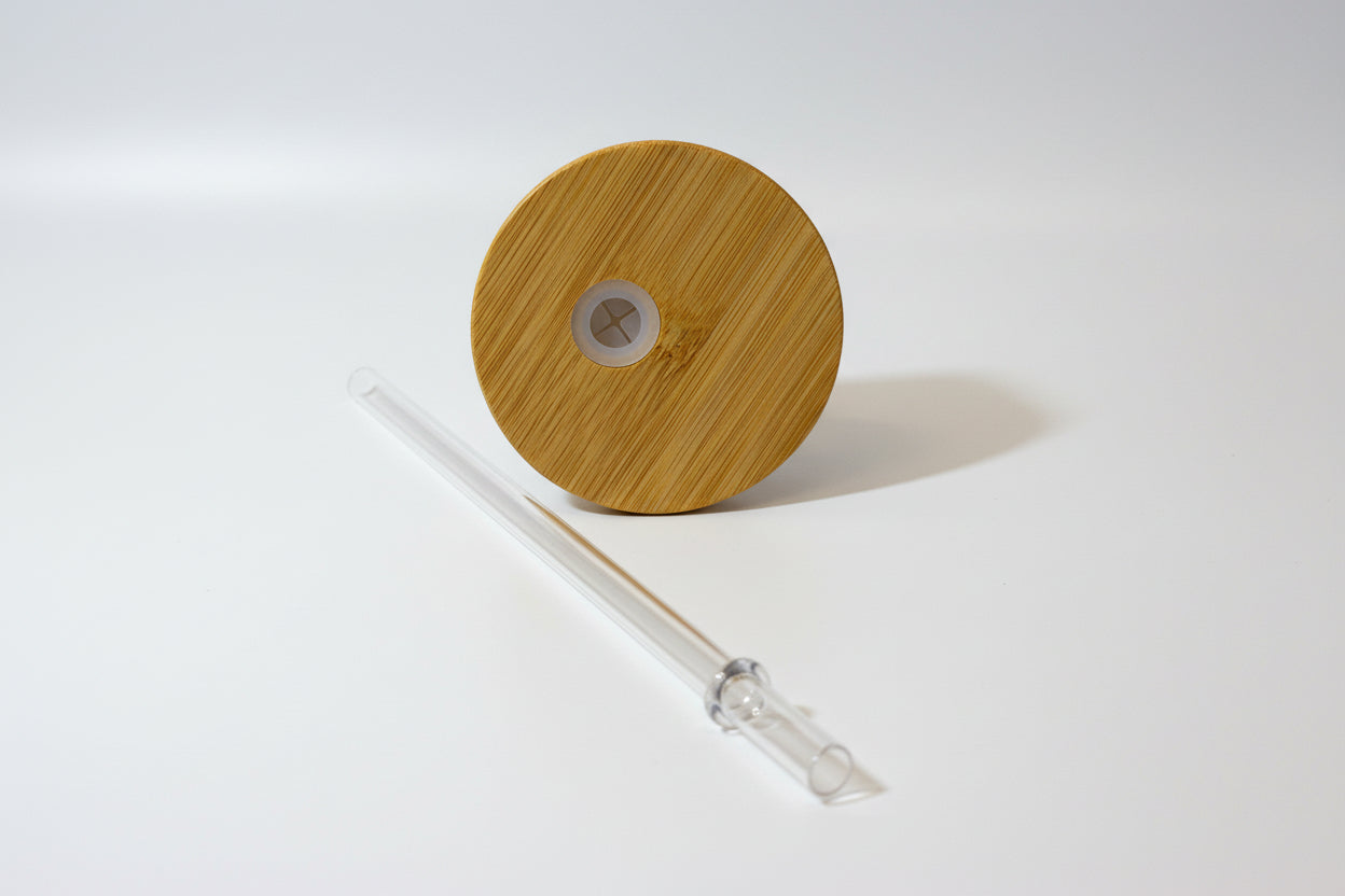 Wooden lid with a clear straw on a white background