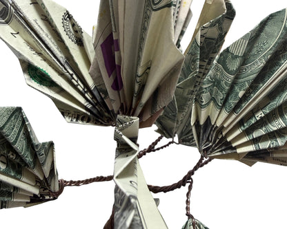 Fanned-out dollar bills arranged in a circular pattern on a white surface.