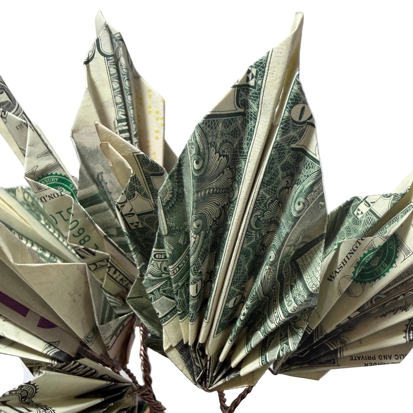 Origami leaf made from dollar bills on a white background