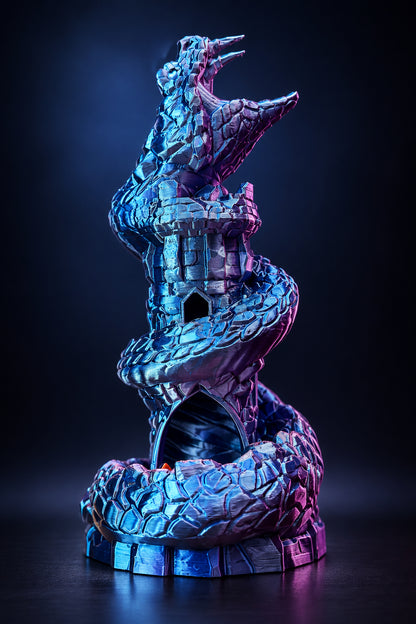 A 3D-printed snake figurine coiled around a miniature castle tower, featuring a metallic blue and purple iridescent finish, set against a dark studio background.