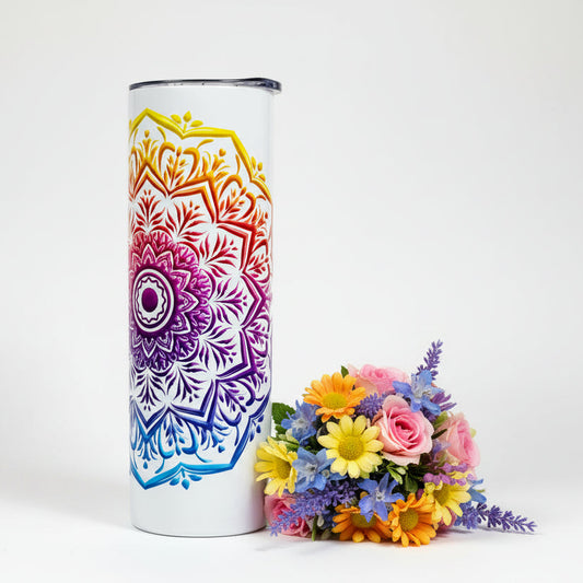 Tumbler with a colorful mandala design next to a bouquet of flowers on a white background
