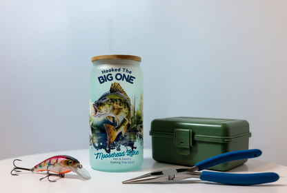 Fishing-themed tumbler with a fish design, next to fishing tackle on a white background