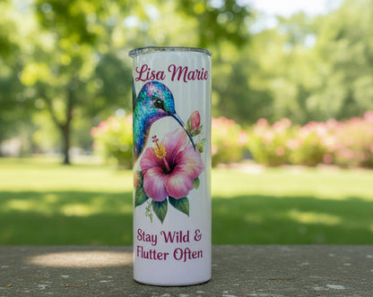 Tumbler with a colorful hummingbird and flower design on a white background
