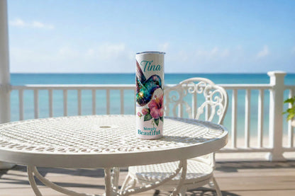 Tumbler with a colorful bird and floral design on a white background