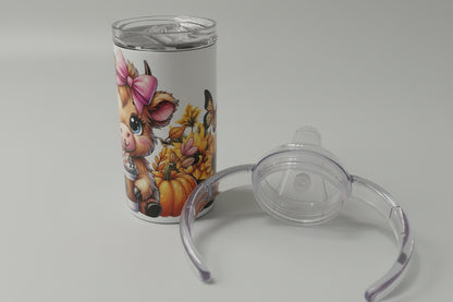 Tumbler with animal design and clear baby bottle nipple on a white surface